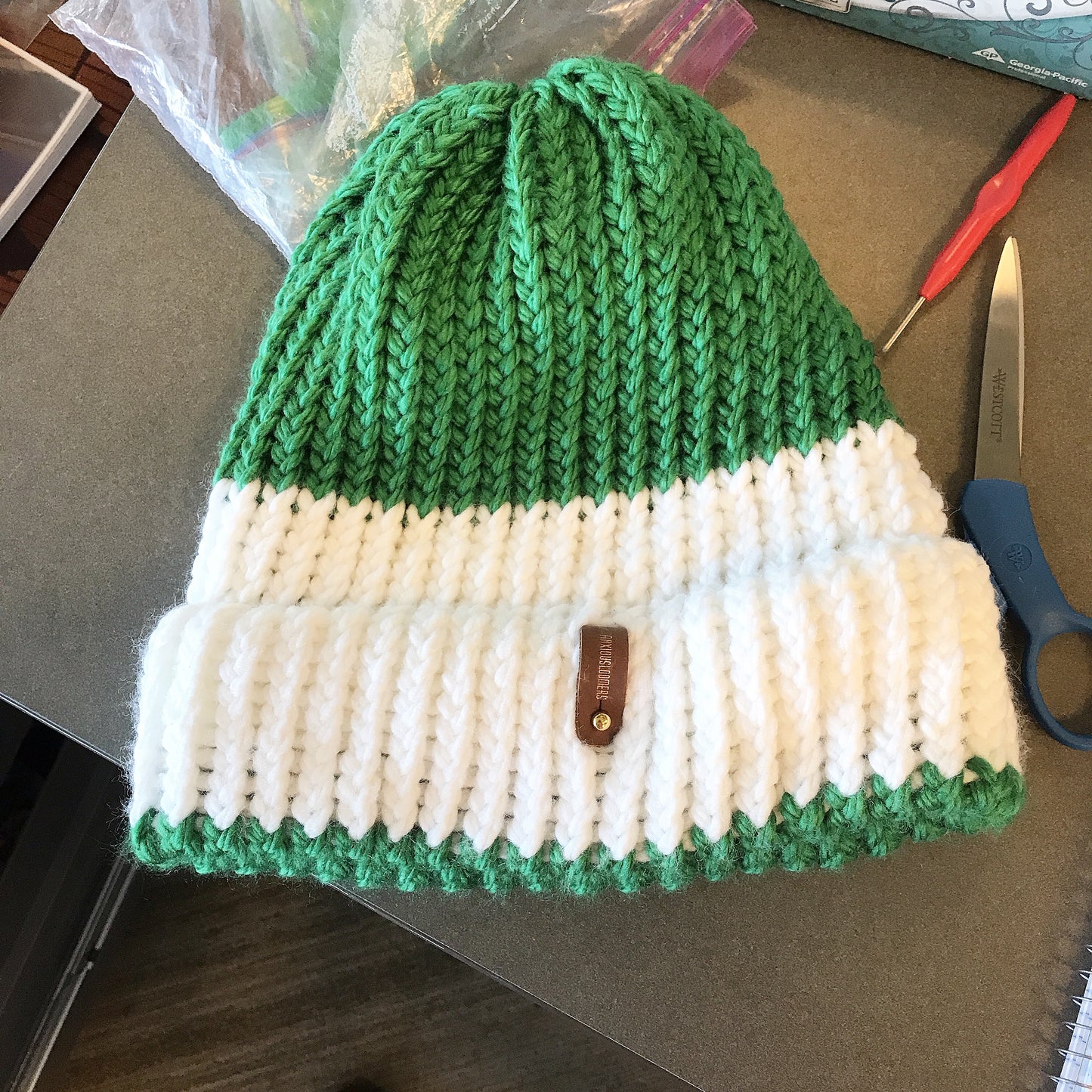 GREEN AND WHITE HAT WITH ANXIOUSLOOMERS TAG
