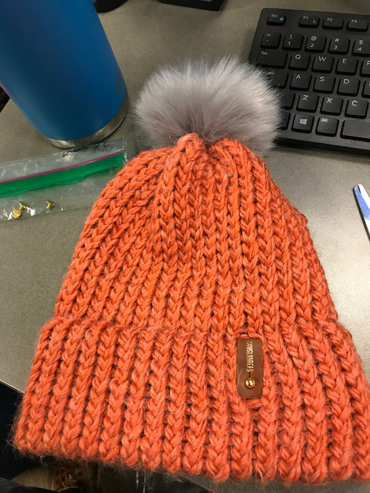 ORANGE HAT, GREY POMPOM WITH ANXIOUSLOOMERS TAG