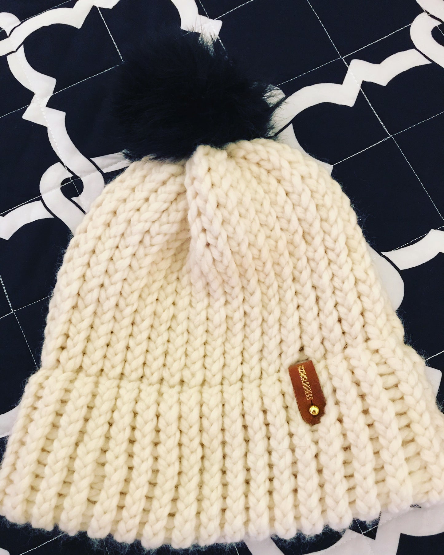 CREAM HAT WITH BLACK POMPOM